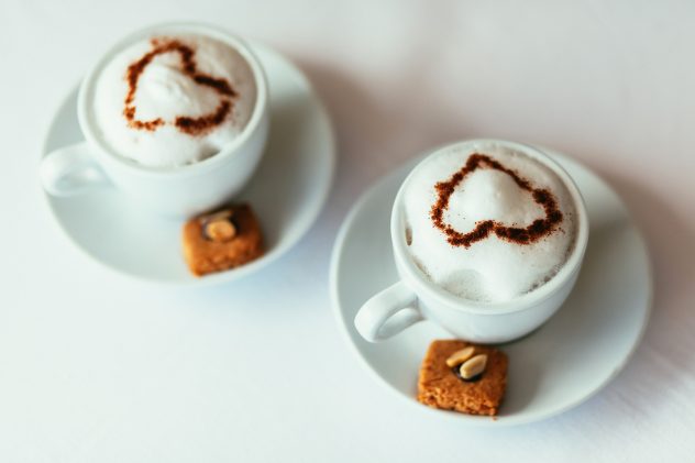 Two cups of cappuccino with cookies and nuts coffee