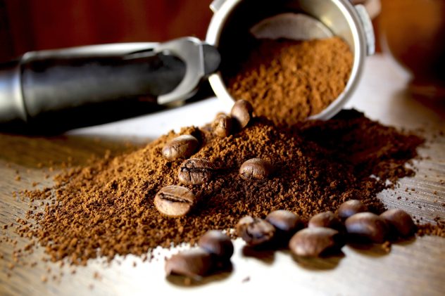 Ground coffee and beans on wooden background beans