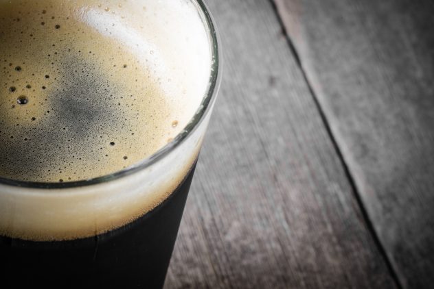 Pint of Dark Beer on Wood Background alcohol