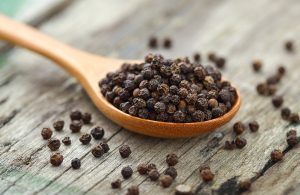 Säästä ranteitasi, rakenna pippurimyllypora Whole black pepper on wooden spoon