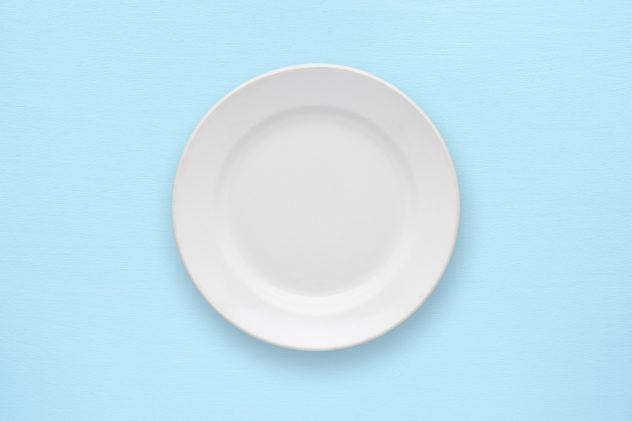 White empty plate top view on table