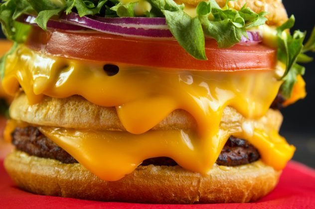 Lot of melting cheese in burger closeup