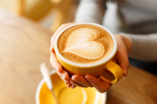 lady’s hands holding cup with sth heart-shaped COFFEE CAPPUCCINO