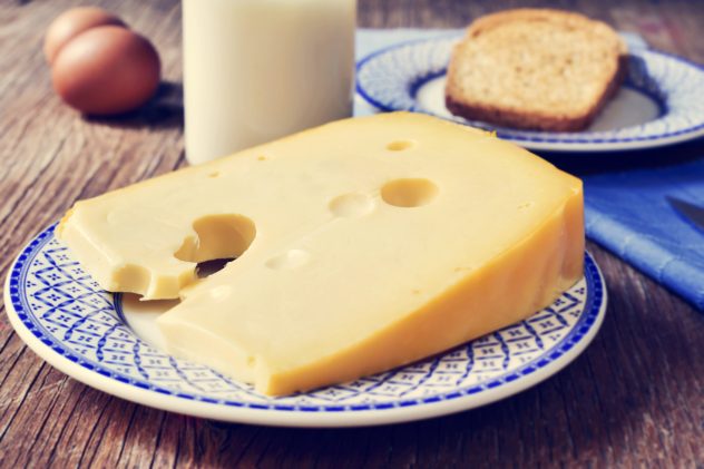 cheese, milk, eggs and bread on a rustic wooden table