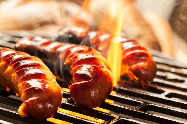 Grilling sausages on barbecue grill