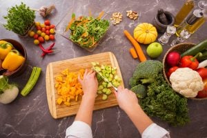 Woman chopping vegetables on wooden board cooking