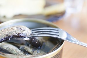 Fork and canned food fish herring
