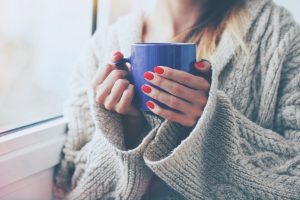 hands holding hot cup of coffee or tea in morning coffee drink