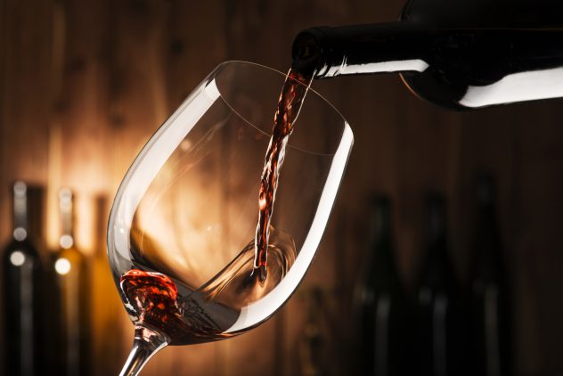 Glass with red wine alcohol bottle