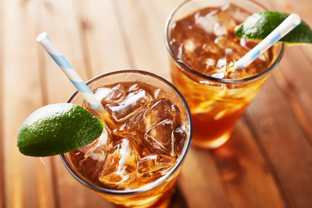 iced sweet tea with lime wedges and retro paper straw shot from angle looking down icetea