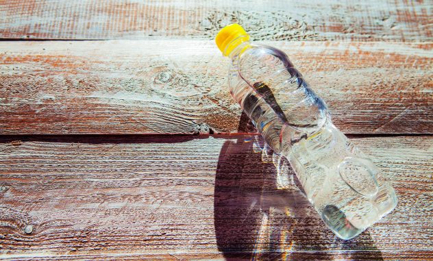 a bottle with water is isolated on a wooden background