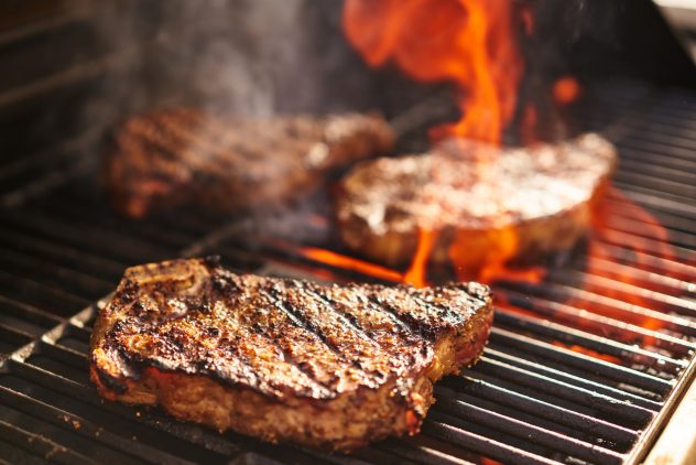 steaks cooking over flaming grill bbq barbeque