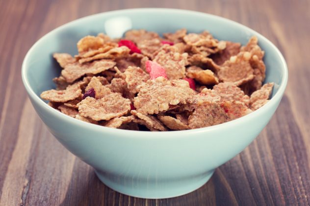 cereals in blue bowl on brown wooden background
