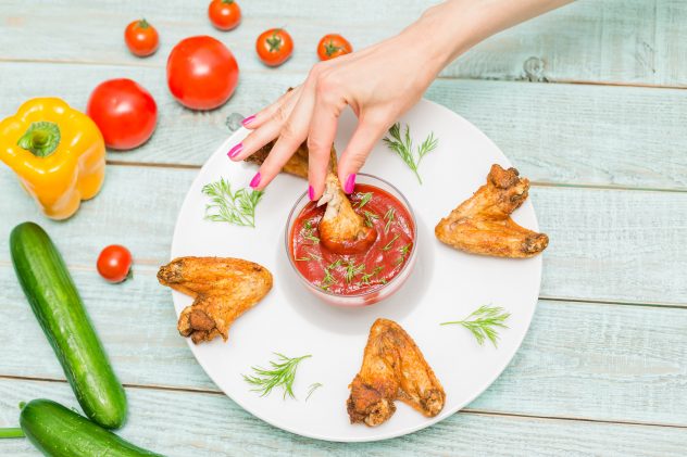 fried chicken wings with ketchup and fresh vegetables