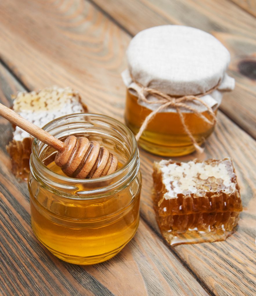 Jars of honey on a old wooden background