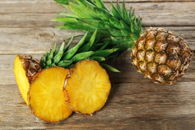 Ripe pineapples on a grey wooden background
