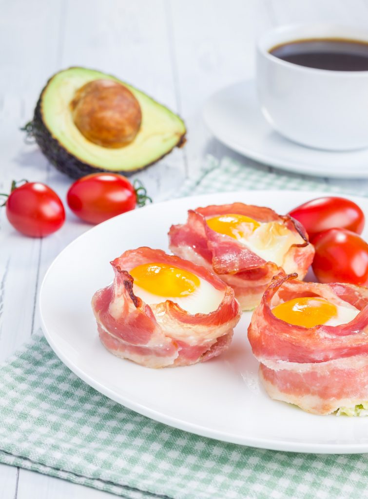 Baked eggs with avocado in bacon cups for breakfast