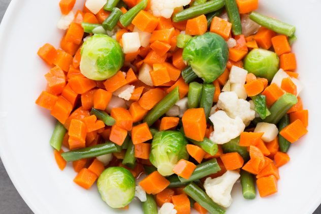 Fresh vegetables mix in a white bowl cooked bright