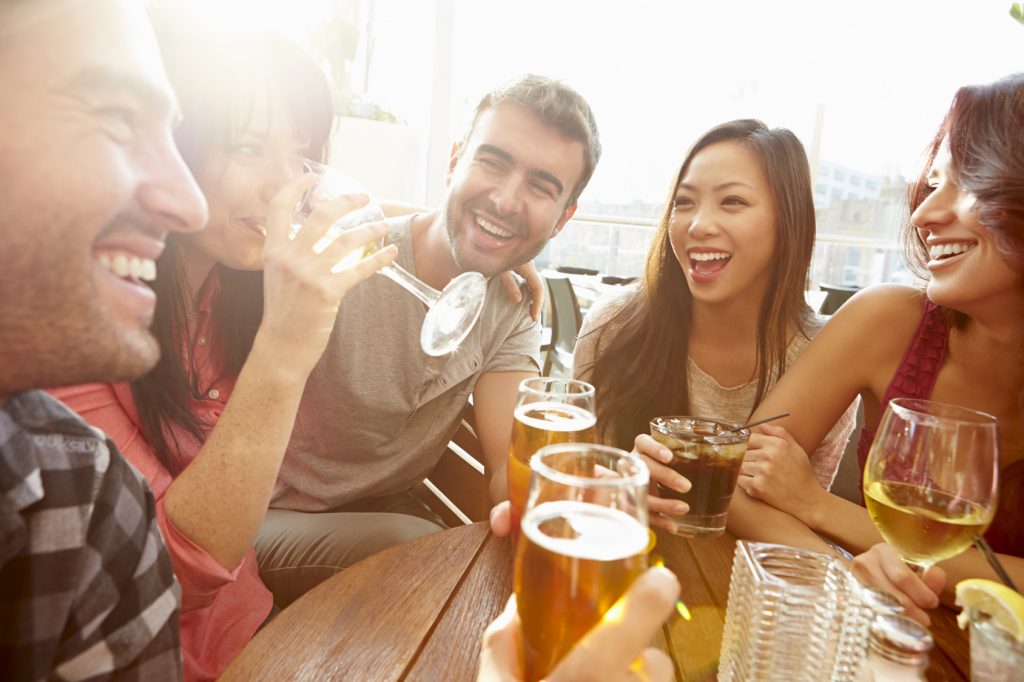 Group Of Friends Enjoying Drink At Outdoor Rooftop Bar