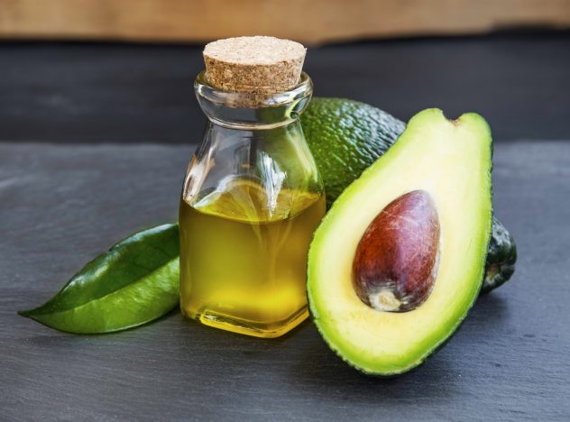 Avocado oil in bottle with avocado fruit