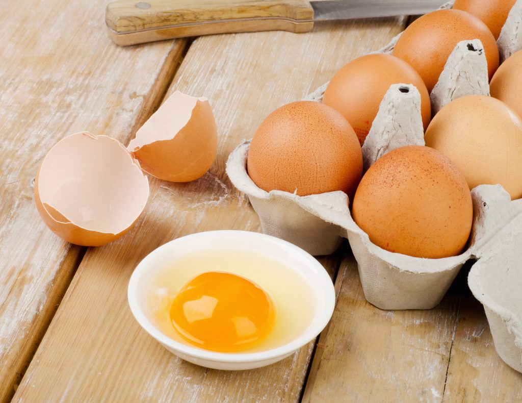 Fresh brown eggs on a wooden table. Selective focus