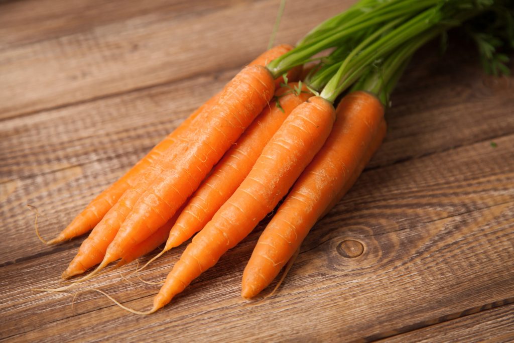 Raw carrot on a wooden table