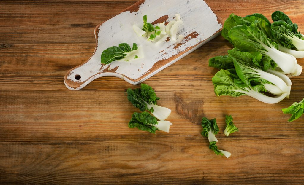 Chinese cabbage, Bok Choy on a wooden table. Top view