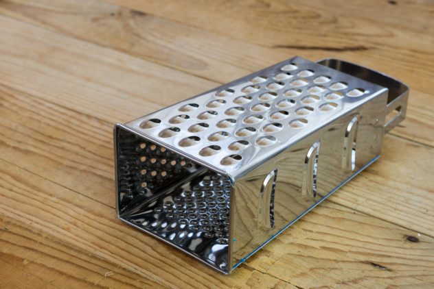New metal grater on the old wooden table kitchen