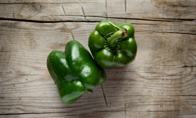 top view of green bell pepper on wooden table