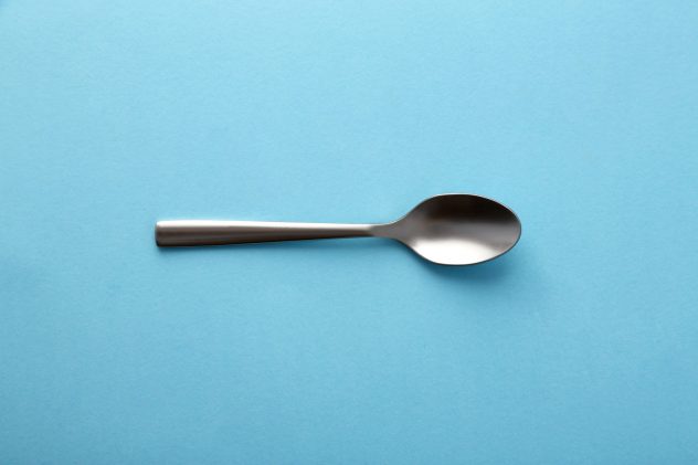 Dessert spoon on blue background