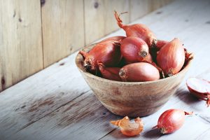 Shallot on a rustic wooden table.Selective focus