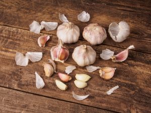 Garlic Heads And Cloves On Old Wooden Table peel peeled