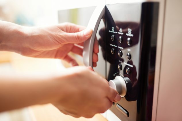 Using microwave oven, close up photo, shallow dof micro cooking food warming heating