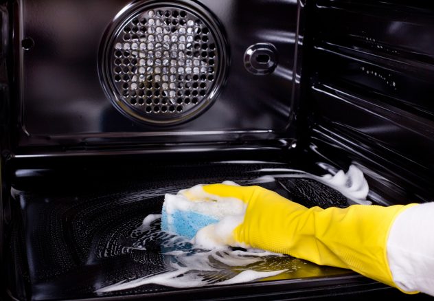 Woman cleaning oven