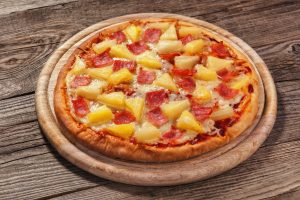 Hawaiian pizza on the old board