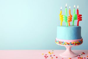 Birthday cake with candles on turquoise  background.