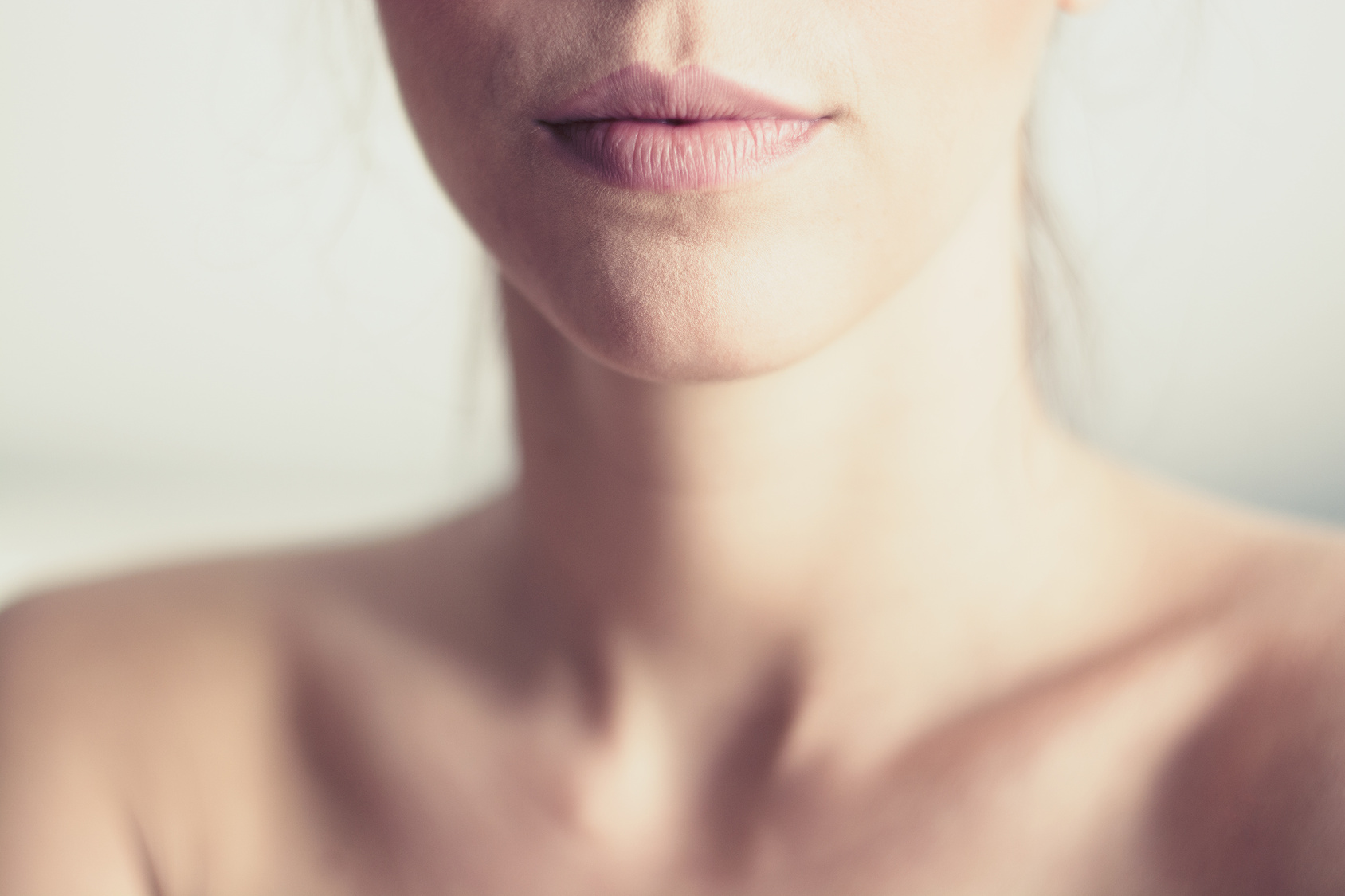 Closeup of young woman's pink lips and neck