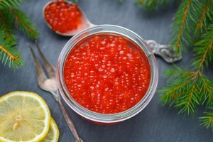 Salmon caviar. Red caviar and lemon. New year. Traditional Russi