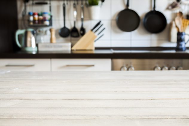 Empty white wooden table and blurred kitchen background, product display