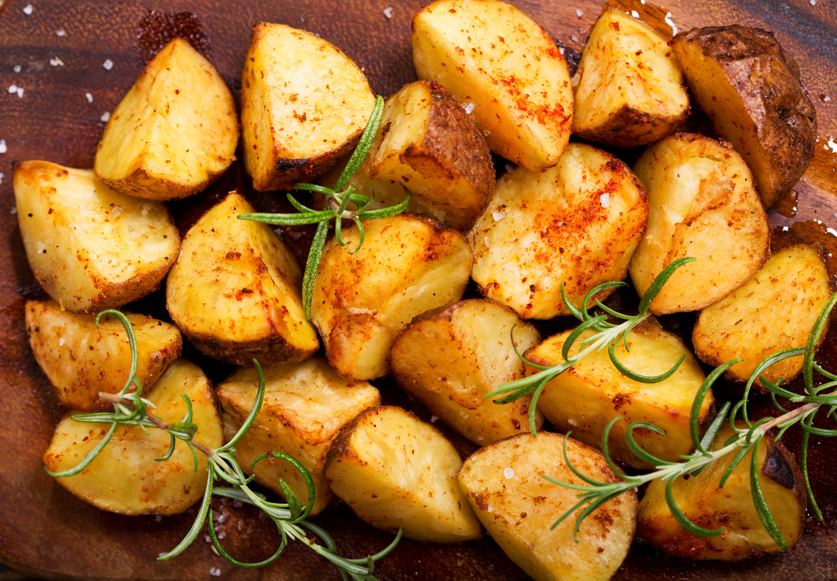 roasted potatoes with rosemary on wooden board