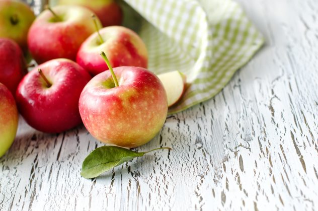 Red fresh juicy apples from garden wooden background copy space