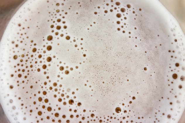 A close up of beer with bubbles on top