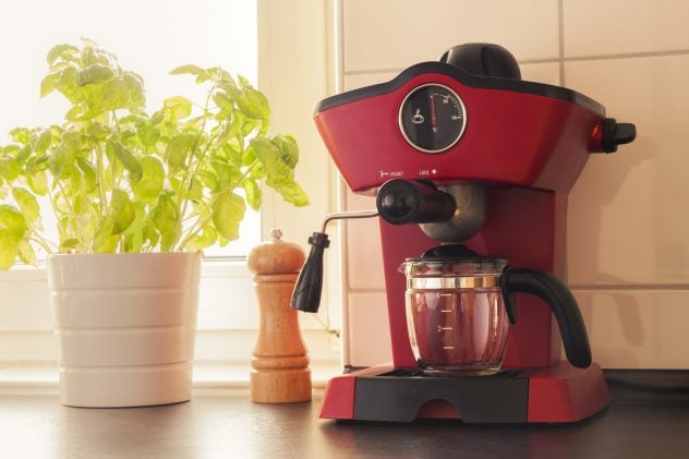 A red vintage looking espresso coffee machine in kitchen