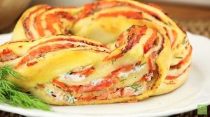 Kääri pizzapohjaan juustoista täytettä ja lohta – lopputuloksena uskomattoman kauniit pikkusuolaiset lohirulla