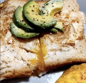 Nainen rikkoo kananmunat pannulle paahtoleivän päälle – maukas aamiainen on valmis! Kananmunaleipa