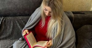 nainen-lukee-kirjaa-sohvalla